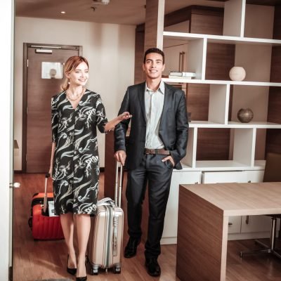 Wife and husband feeling excited entering their hotel room Wife and husband. Stylish wife and husband feeling excited while entering their hotel room
